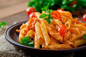 Wall Mural - Penne pasta in tomato sauce with chicken, tomatoes