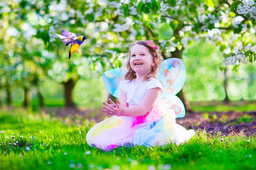 Wall Mural - Little girl in fairy costume feeding a bird