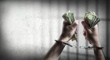 Arrest For Corruption - Man Handcuffed Holding Dollars
