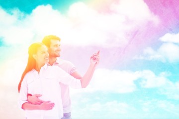 Poster - Composite image of cute couple embracing and pointing