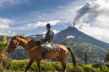 Unrecognizable Farmer On A Horse Front Of Volcano Tungurahua