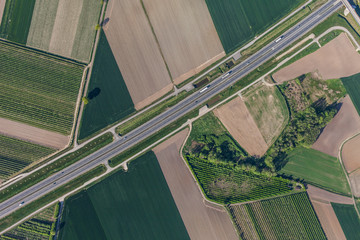 Wall Mural - aerial view of highway and green harvest fields