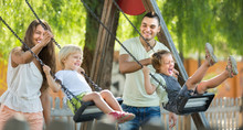 Parents With Kids At Swings