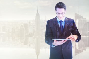 Poster - Composite image of businessman standing while using a tablet pc