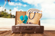© Jag_cz - Travel concept with old suitcase on wooden planks