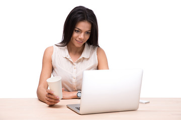 Wall Mural - Happy businesswoman sitting at the table with laptop