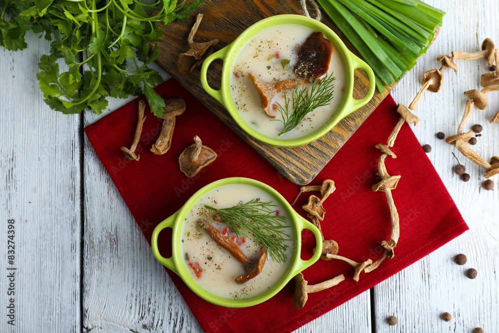 Mushroom soup on wooden table with red napkin, top view