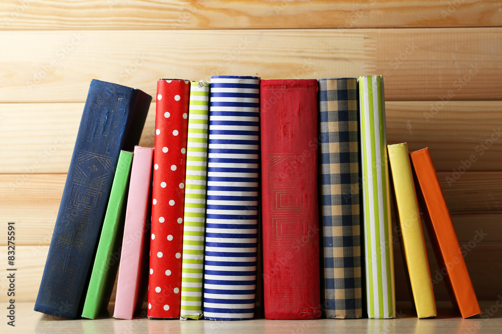 Books on shelf, close-up, on wooden background