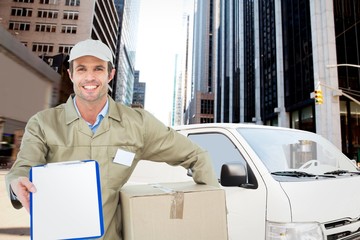 Poster - Composite image of happy delivery man with box showing clipboard