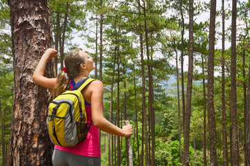 Wall Mural - Portrait of happy traveler woman  in forest enjoying sunny day