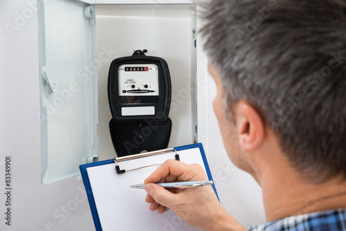 Fotografie, Obraz Technician Taking Reading Of Electric Meter