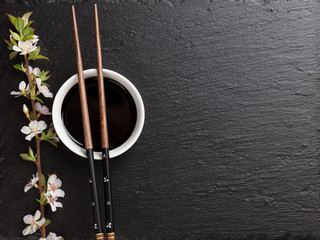 Japanese sushi chopsticks, soy sauce bowl and sakura blossom