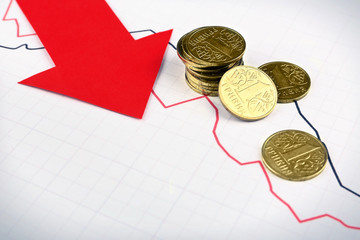 Coins and red arrow on graph document close up