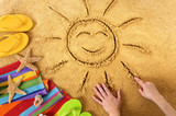 Summer beach smiling sun happy smiley face drawing drawn in sand with accessories holiday vacation photo