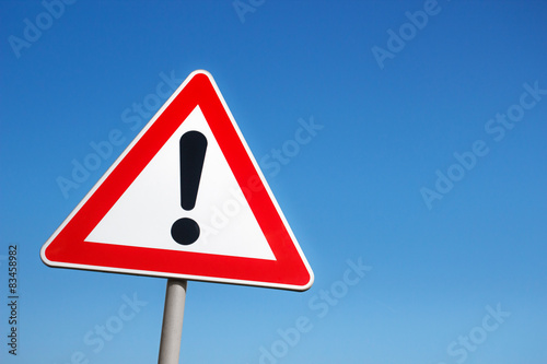 Cuadros en Lienzo Warning road sign against a blue sky.