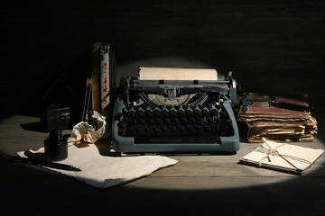 Wall Mural - Retro typewriter in lamplight on wooden background