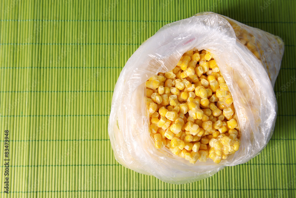 Frozen corn in bag on bamboo mat background