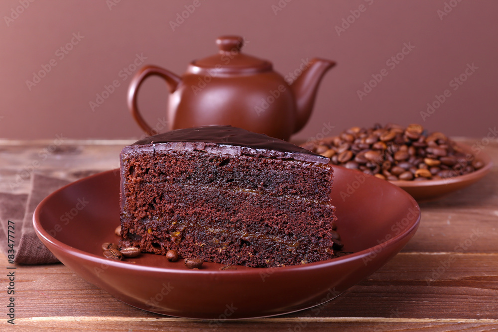 Delicious chocolate cake with coffee beans on plate on table close up
