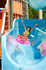 Wall Mural - Child on water slide at aquapark.