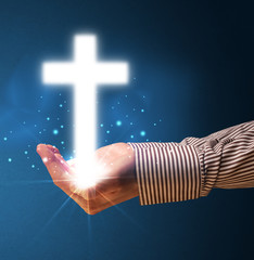 Wall Mural - Glowing cross in the hand of a businessman