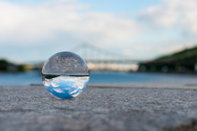 Glass Transparent Ball On Bridge Background And Grainy Surface