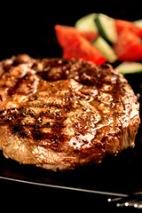 Wall Mural - Grilled steak and vegetables on black plate vertical