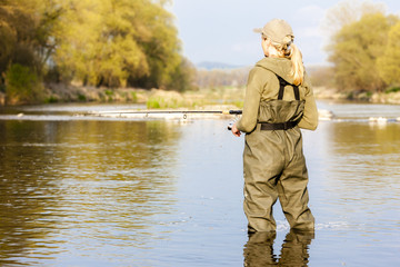 Wall Mural - woman fishing in the river in spring