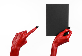 Red devil hand with black nails holding a blank black card