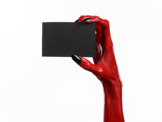 Red devil hand with black nails holding a blank black card