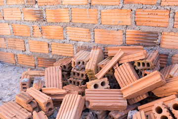 Canvas Print - pile of bricks in construction site with brick wall background