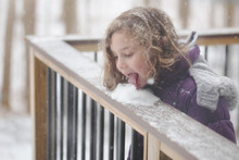 Girl (6-7) Licking Snow