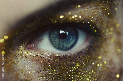 Poster Close-up of woman eye with gold glitters