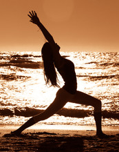 Woman Practicing Yoga On Beach