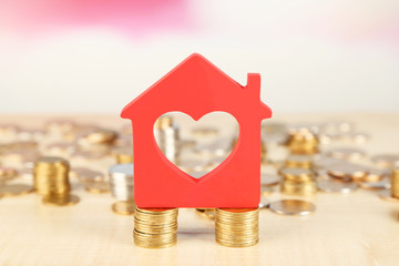 Canvas Print - Model of house with coins on bright background