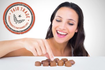 Poster - Composite image of pretty brunette picking out chocolate
