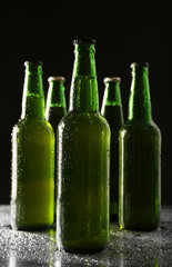 Poster - Glass bottles of beer on dark background