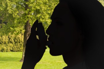 Poster - Composite image of asthmatic brunette using her inhaler 