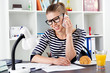 © Stasique - Young casual female tax consultant talking on phone at home