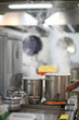 Cooking in a restaurant kitchen, steam over cooking pots