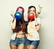 © Raisa Kanareva - hipster girls smiling and holding colored balloons