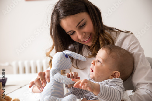 Fototapeta Mother and her baby playing with toys.