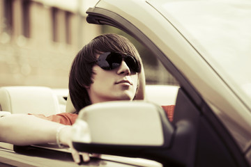 Young handsome fashion man driving convertible car