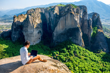 man with laptop on the mountains