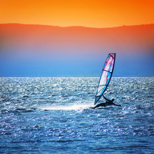 Windsurfer Silhouette Against A Sunset Background