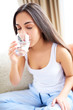 © Flamingo Images - Woman drinking glass of water  leaning forward.