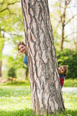 Wall Mural - Mother and son peeking out from behind the tree 