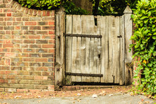 Rustic Old Wooden Gate In Brick Wall