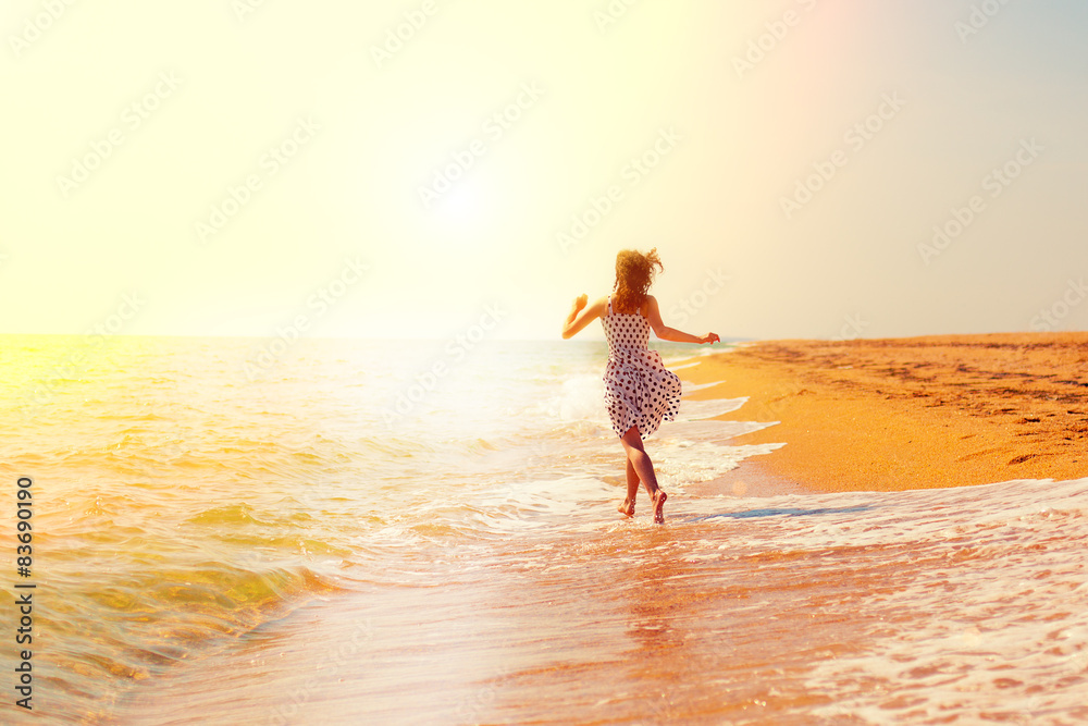 Happy girl running on the beach towards the sun Stock Photo | Adobe Stock