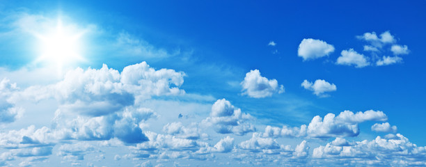 white heap clouds and bright sun in the blue sky.