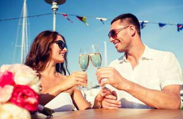 smiling couple drinking champagne at cafe